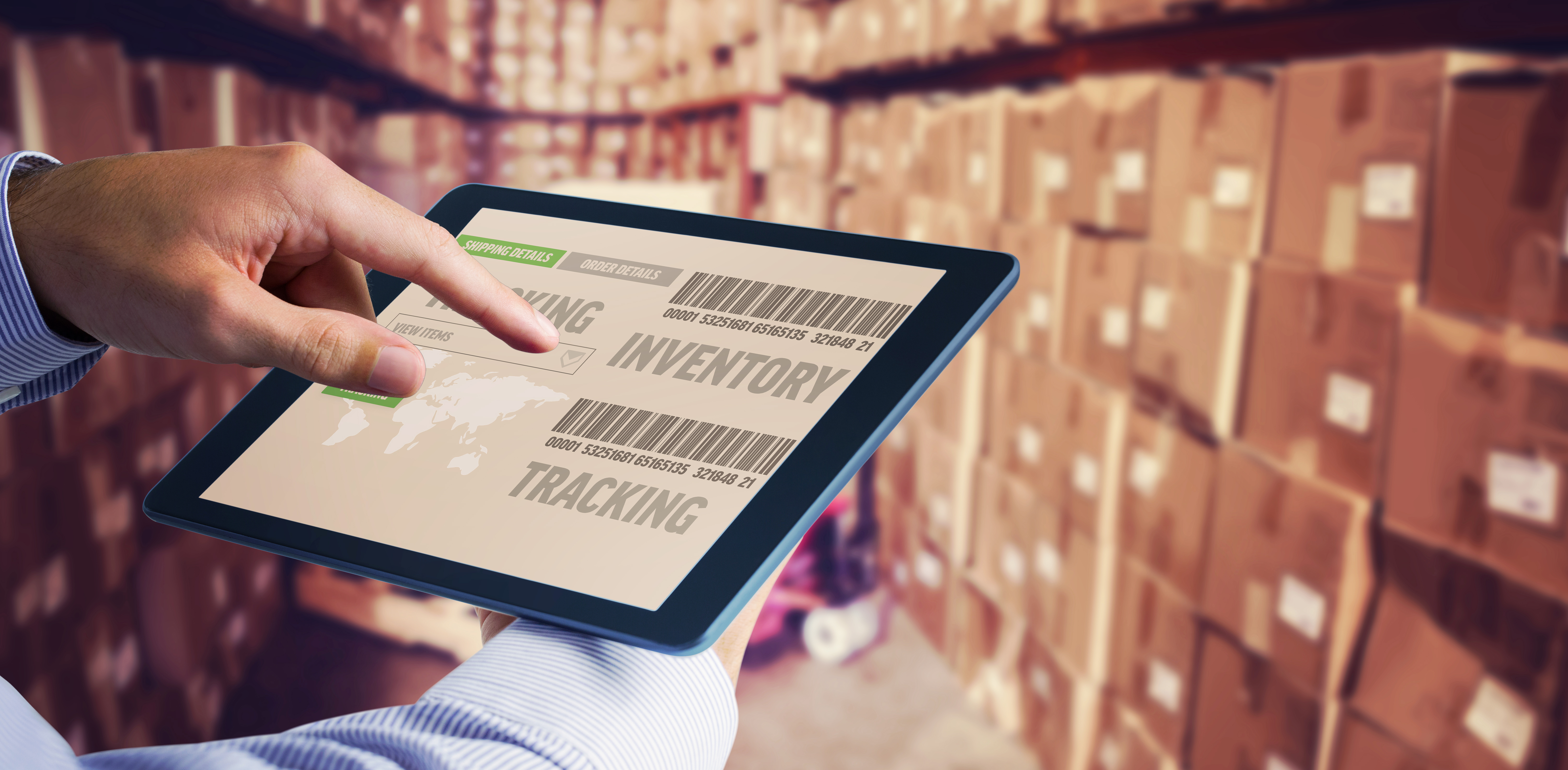 man-using-tablet-pc-against-boxes-warehouse